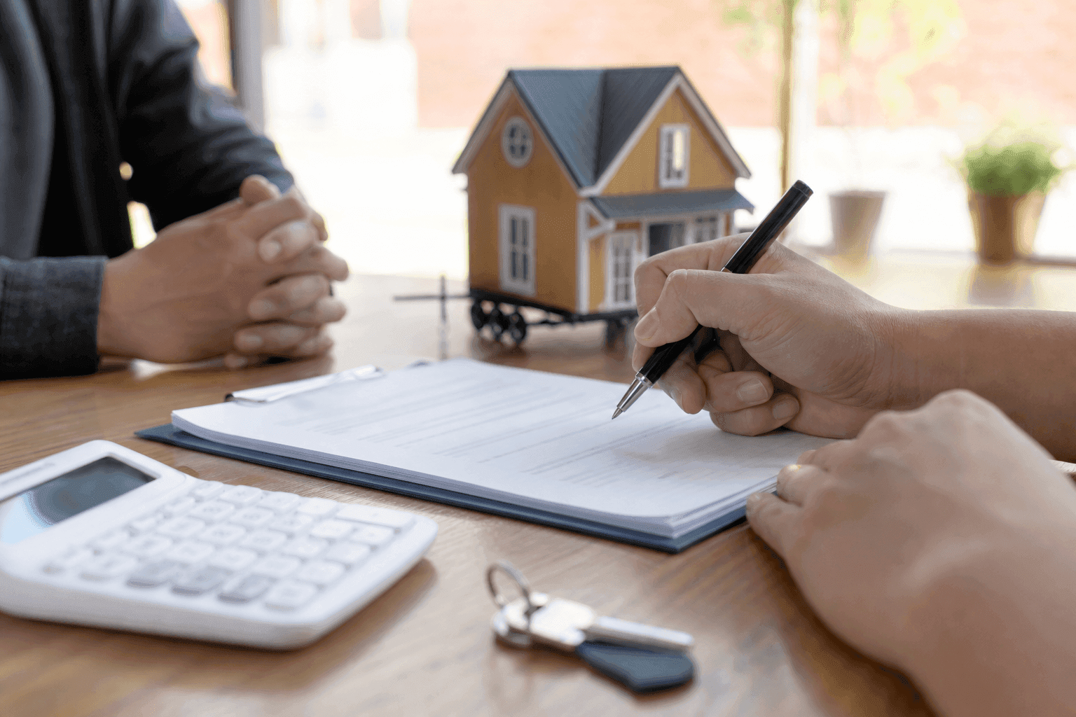 Loan documents, calculator and tiny house model showing financing approval process and payment schedules