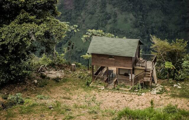 Tiny house with solar panels and rainwater collection system in natural setting demonstrating off-grid living